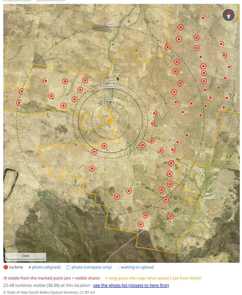 The Bookham site map
        with an amber crosshair placed, red rings on the turbines visible
        from it, dashed distance rings and a scale bar